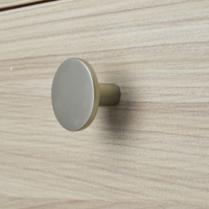 Round knob on light wood drawer